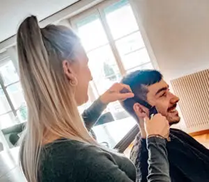 Jacky frisiert einen Kunden bei der Arbeit im Friseursalon